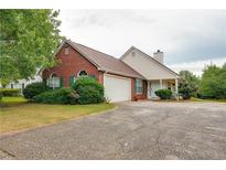 Charming brick home featuring an attached garage and well-maintained front yard landscaping at 12384 Riviera Dr, Fayetteville, GA 30215