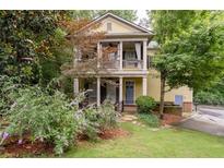 Charming two-story home featuring a welcoming front porch and second story balcony, surrounded by lush greenery at 635 Holcomb Bridge Rd, Norcross, GA 30071
