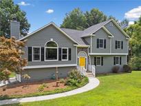 Charming home with gray siding, black shutters, and a cheerful yellow front door at 1400 Land Rd, Canton, GA 30114
