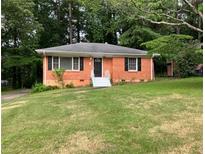 Charming single-story brick home with a well-maintained lawn and mature trees at 3160 Delowe Dr, Atlanta, GA 30344