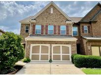 Charming brick townhome featuring a two-car garage and well-maintained landscaping at 3534 Clancy Way, Smyrna, GA 30080