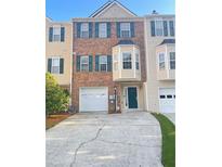Two-story townhouse with brick facade, a driveway, attached garage and well-kept front yard at 795 Abbotts Mill Ct # 73, Johns Creek, GA 30097