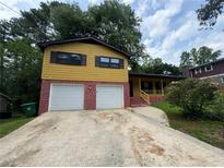 Charming two-story home featuring a two-car garage, a welcoming porch, and a well-maintained front yard at 4246 Rue Saint Michel, Stone Mountain, GA 30083