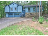 Charming two-story home with a two-car garage and a stone accent wall, surrounded by lush greenery at 2685 Peachtree Walk Walk, Duluth, GA 30096