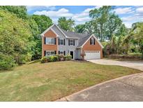 Charming two-story home with brick and gray siding, well-manicured lawn, and attached two-car garage at 5705 Cannonero Dr Dr, Alpharetta, GA 30005