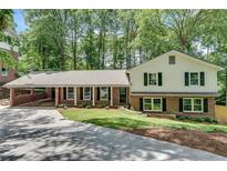 Charming home featuring a carport, well-maintained lawn, and classic brick and siding facade at 2689 Cosmos Ne Dr, Atlanta, GA 30345