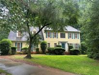 Charming two-story home featuring a manicured lawn, traditional architecture, and lush landscaping at 218 Oakmoor Ct, Lawrenceville, GA 30043