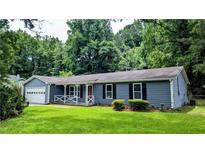 Charming single-story home featuring a front porch, attached garage, and lush green lawn at 5177 Mccarter Sta, Stone Mountain, GA 30088