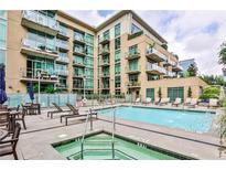 Inviting outdoor pool area with lounge chairs and a hot tub for relaxation in a modern condo complex at 905 Juniper Ne St # 701, Atlanta, GA 30309