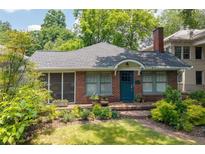 Charming brick home with landscaped front yard, screened porch, and blue front door at 1300 North Ne Ave, Atlanta, GA 30307