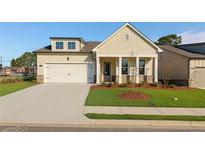 Charming single-story home boasts a manicured lawn, covered porch with columns, and an attached two-car garage at 1693 Juniper Berry Way, Loganville, GA 30052