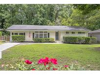 Charming single-story home with a well-manicured lawn, flowering shrubbery, and a welcoming exterior at 2070 Drew Valley Ne Rd, Brookhaven, GA 30319