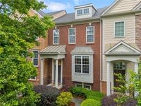 Brick townhome featuring manicured landscaping and inviting covered entryway and steps at 4879 Seldon Se Way, Smyrna, GA 30080
