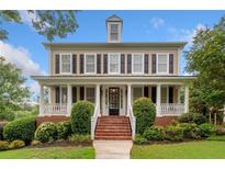 Charming two-story home featuring a welcoming front porch and manicured landscaping at 1235 Renaissance Se Ct, Mableton, GA 30126