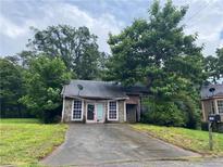 Exterior shot of a home with stone facade and overgrown greenery at 5035 Chadwick Ct, Decatur, GA 30035