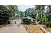 Charming single-story home with a two-car garage and lush landscaping at 1127 Renee Dr, Decatur, GA 30035