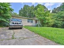 Charming single-story home with well-maintained front lawn and a long concrete driveway at 504 Rock Meadow Dr, Stone Mountain, GA 30088