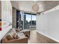 Bright living room features city views, hardwood floors, and a modern lighting fixture at 860 Peachtree Ne St # 1806, Atlanta, GA 30308