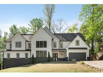 Beautiful two-story home featuring a black roof, white siding, black framed windows, and a well-manicured front yard at 4201 Brookview Se Dr, Atlanta, GA 30339