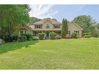Inviting two-story home with well-manicured lawn and classic architectural details at 5154 Meadowbrook Cir, Suwanee, GA 30024