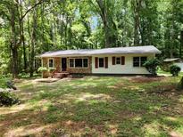 Charming single-story home featuring stone accents and red shutters, nestled among mature trees on a spacious lot at 3705 Orchard Dr, Atlanta, GA 30349