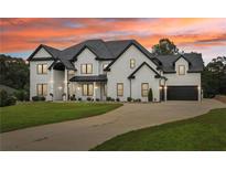 Stunning two-story home boasts modern farmhouse design with white brick, black accents, and lush front lawn at 3735 Hamilton Mill Rd, Buford, GA 30519