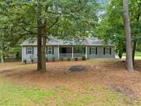 Charming single-story home features a symmetrical facade, gray siding, and a welcoming front porch at 3235 Harms Way, Snellville, GA 30039