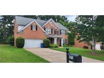 Charming two-story brick home featuring a well-manicured lawn, mature trees, and a two-car garage at 571 Cold Water Ln, Mcdonough, GA 30252
