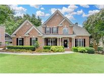 Charming brick home with manicured lawn, lush landscaping and inviting front porch at 1640 Mount Mckinley Dr, Grayson, GA 30017