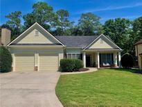 Charming ranch home with a well-manicured lawn, covered porch, and a two-car garage at 518 Oriole Farm Trl, Canton, GA 30114