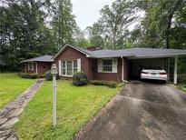 Charming brick home with a carport and well-maintained lawn and mature trees at 127 Pirklewood Cir, Cumming, GA 30040