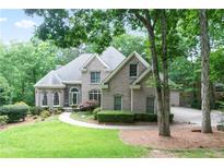 Beautiful brick home featuring a well-manicured lawn and mature trees offering a serene, picturesque setting at 920 Waters Reach Ct, Alpharetta, GA 30022