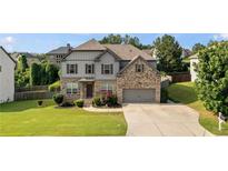 Beautiful two-story home with manicured lawn, gray siding, brick accents, and a two-car garage at 108 Fountain Oak, Villa Rica, GA 30180