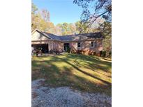 Charming brick home featuring a well-maintained lawn and attached garage at 6340 Koweta Rd, Fairburn, GA 30213