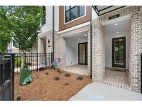 Inviting front entrance with brickwork, covered porch, and modern black door at 334 Olmstead Way # 37, Alpharetta, GA 30022