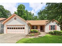 Charming single-story home with attached garage, manicured lawn, and mature trees at 885 Falling Water Ln, Norcross, GA 30093