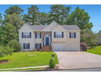 Charming two-story home featuring a stone accent, blue shutters, and a well-manicured lawn at 3290 Spincaster Way, Loganville, GA 30052