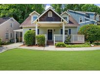 Charming home featuring a well-manicured lawn, inviting front porch, and classic architectural details at 176 Rockyford Ne Rd, Atlanta, GA 30317