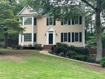 Charming two-story home with manicured lawn and classic design details like black shutters and bay windows at 3641 Bramblewood Way, Marietta, GA 30062