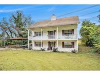 Charming two-story home featuring a welcoming porch on both levels and a spacious front yard with convenient carport at 4141 Willow Ridge Rd, Douglasville, GA 30135