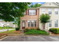 Charming brick-front townhome featuring neat landscaping and a welcoming entrance at 1343 Penhurst Dr, Lawrenceville, GA 30043