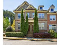 Charming townhome with well-manicured landscaping and a welcoming facade on a clear, sunny day at 7275 Highland Blf # 8, Atlanta, GA 30328