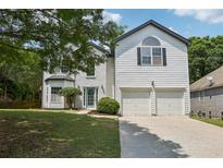 Charming two-story home with a well-maintained lawn and a two-car garage at 1025 Pebble Creek Trl, Suwanee, GA 30024