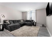 Comfortable living room showcasing a plush gray sectional sofa, soft rug, and stylish decor at 1421 Peachtree Ne St # 401, Atlanta, GA 30309