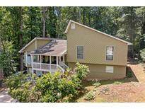 Charming home with a covered porch nestled among lush greenery and mature trees at 592 Ferry Creek Ct, Acworth, GA 30102