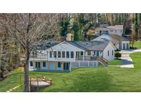 Stunning white home with a finished terrace level and rear decks overlooking the lush backyard at 6313 Shoreland Cir, Buford, GA 30518