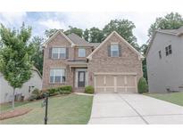 Charming two-story brick home featuring manicured lawn and a two-car garage with an inviting entrance at 2870 Prestwood Dr, Cumming, GA 30040