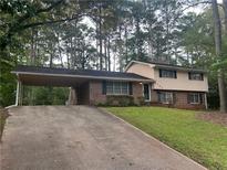 Charming two-story home with a covered parking area and well-maintained front lawn at 4902 Pine Hill E Ct, Stone Mountain, GA 30088