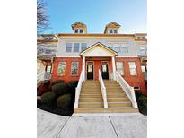 Charming brick townhome featuring a welcoming front porch and well-maintained landscaping at 4438 Lassen Ct, Suwanee, GA 30024