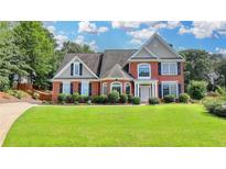 Charming two-story brick home with well-manicured lawn and mature landscaping at 189 Azalea Chase Dr, Suwanee, GA 30024